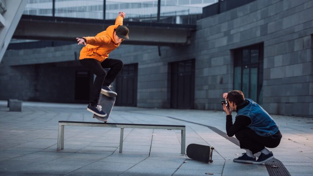 man-taking-photo-of-skateboarder-doing-trick-over-bench-e1633503809501.jpg